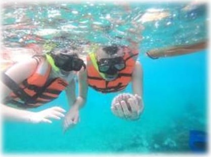 Pareja haciendo Snorkel con chalecos en aguas turquesa