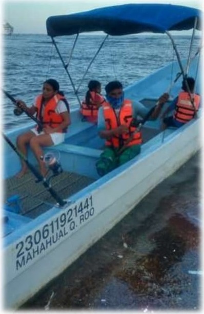 Familia pescando desde la lancha en Mahahual